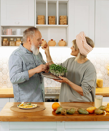 couple eating salad in kitchen