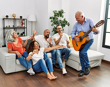 Friends listening to man playing a guitar