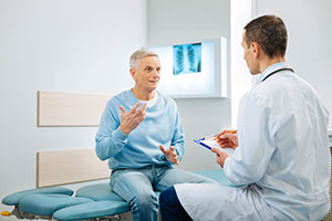 Doctor with male patient in exam room
