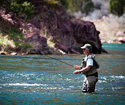 man in river fly fishing