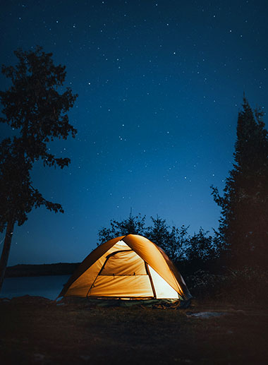 tent illuminated against a starry night
