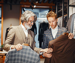 Man shopping in clothing store with salesman