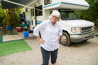 Woman standing in front of her RV in a campground